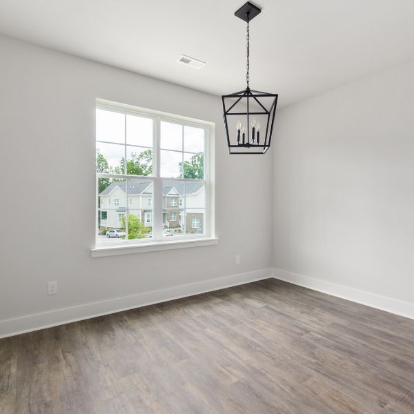 Empty room with a beautiful light fixture and white walls.